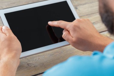 tablet cihaz ahşap çalışma masa üzerinde tutan bir adam elinde