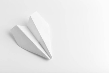 Düz beyaz kağıt uçak beyaz renk arka plan üzerinde yatıyordu