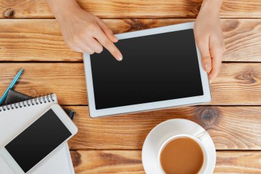 Dijital tablet ve ahşap bir masa üzerinde kahve ile kız el