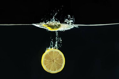 su sıçrama siyah arka plan üzerine taze sarı limon