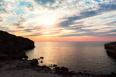 Parlak tatil hedef beach gündoğumu ve deniz kayalıklarla arka plan