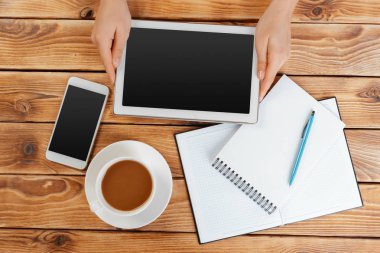 Dijital tablet ve ahşap bir masa üzerinde kahve ile kız el