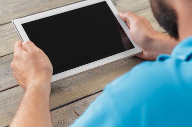 tablet cihaz ahşap çalışma masa üzerinde tutan bir adam elinde