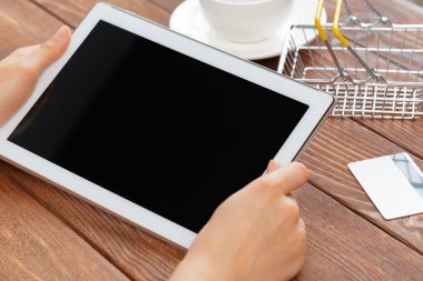 Kadın tablet bilgisayar ve kredi kartı kullanarak alışveriş yapıyor 