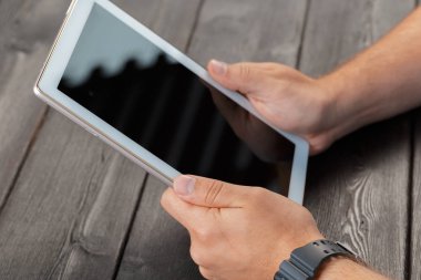 tablet cihaz ahşap çalışma masa üzerinde tutan bir adam elinde