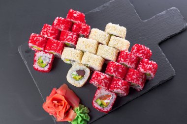 Japon restoranı, suşi rulo siyah arduvaz plaka üzerinde.