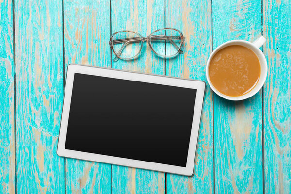 digital tablet and coffee cup on wooden table