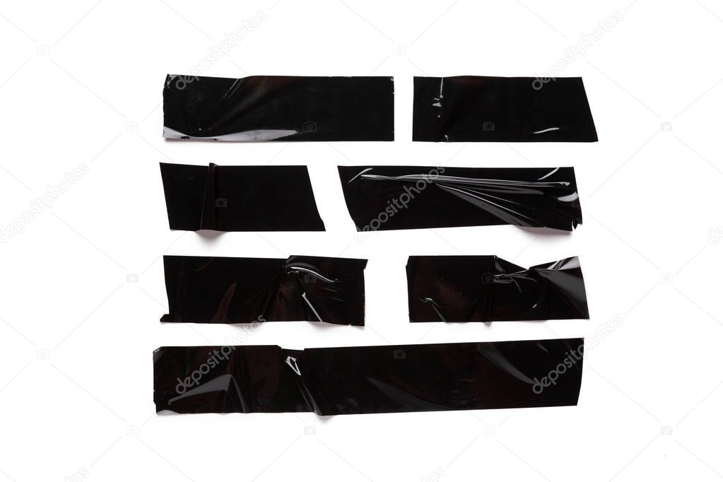 A collection of used black electrical tape pieces isolated on white background