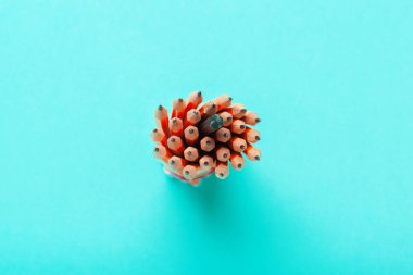 Mavi arka plan üst görünümünde bir fincan renkli kalemler