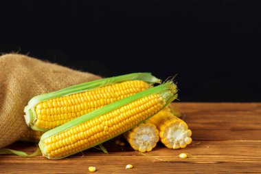 Tahta bir masada çiğ mısır.