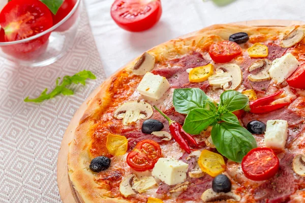 Pizza with Mozzarella, Ham, Cherry Tomatoes, Black Olives