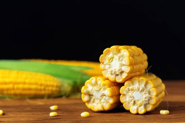 Tahta bir masada çiğ mısır.