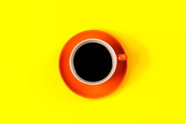 Arka planda bir fincan kahve ve çay tabağı.