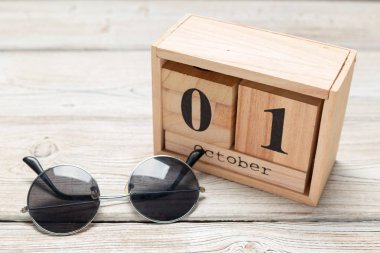 1 Ekim. Ahşap arka plan üzerine beyaz tahta takvim.