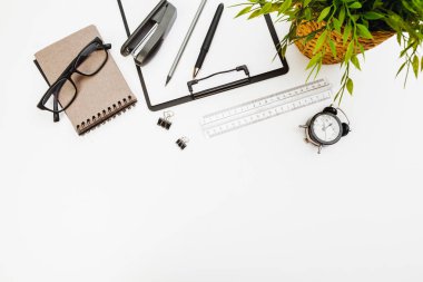 Ofis malzemelerinin olduğu pano beyaz masada, üst görünümde.