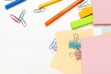 Kalemleri, renkli kalemleri, masa üzerinde ataçları olan yapışkan notlar.