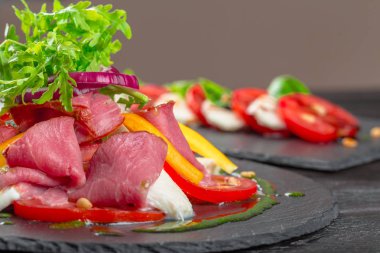 Taze hurma salatası roka, parma jambonu, zeytinyağı ve bitkilerle birlikte. Sonbahar, kış sağlıklı yiyecekler