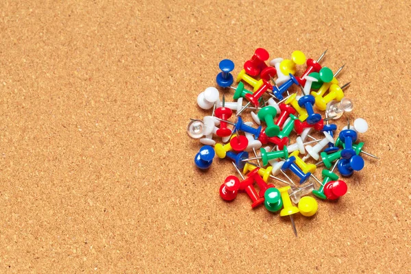 Group of thumbtacks  on corkboard close up. School or business concept