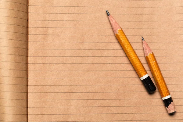 Pencils and notepad paper sheets on gray desk table