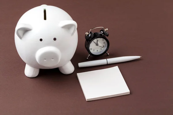 Piggy bank save coin and alarm clock, time and money concept.