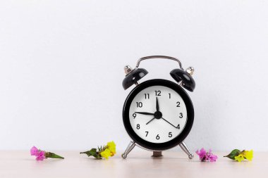 Bir masada yakın kurutulmuş çiçekler ile Çalar saat