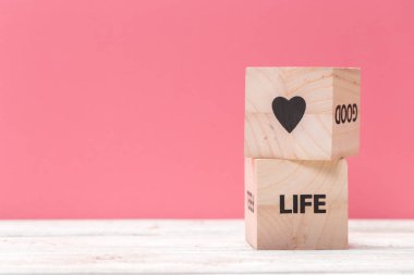 Metin için kopyalama alanı olan pembe arkaplan üzerinde yazı olan tahta küpler