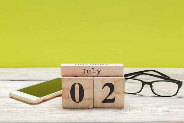 2 july wooden, square calendar. business trip or holiday planning background