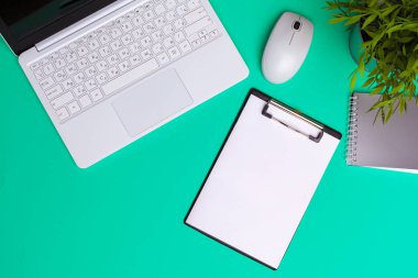 Yeşil arka planda ofis malzemeleri ve kırtasiye malzemeleri.