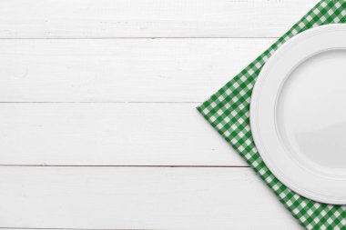 Boş tabak ve havlu ahşap masa arka planında.