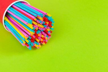 Renkli arka planda meşrubat için renkli pipetler
