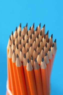 Mavi arkaplanda turuncu kalemler var. Yakın plan.