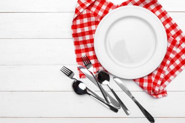 Boş tabak ve havlu ahşap masa arka planında.