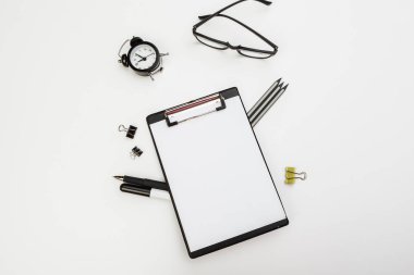 Ofis malzemelerinin olduğu pano beyaz masada, üst görünümde.