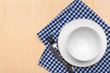 Boş tabak ve havlu ahşap masa arka planında.