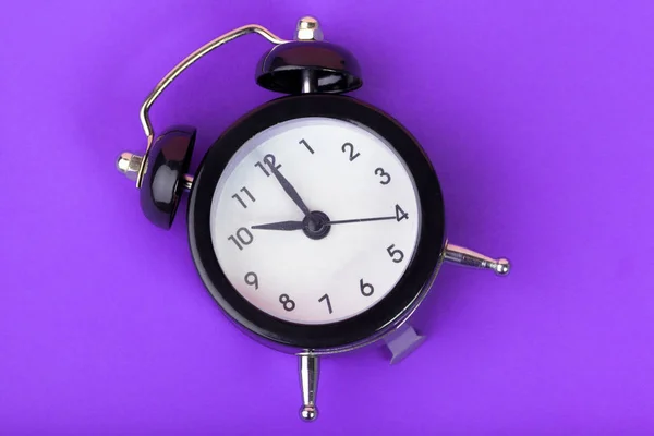 紫丁香背景上的老式黑色警钟 — 图库照片