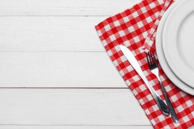 Boş tabak ve havlu ahşap masa arka planında.