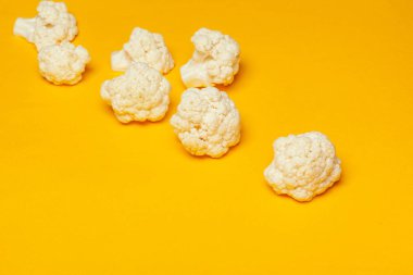 Karnabahar parçaları parlak sarı bir arkaplanda