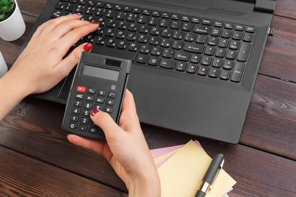 電卓を使って財務データを扱うビジネス女性 — ストック写真