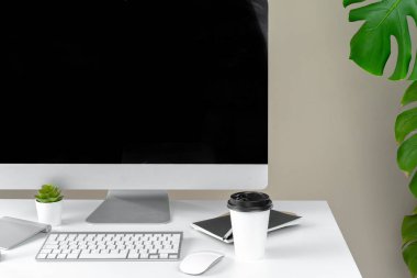 Modern ofiste bilgisayar, klavye, ofis malzemeleri ve tesis ile şık çalışma alanı