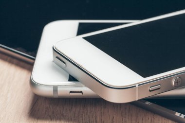 Dijital tablet ve cep telefonu. Ahşap masa üzerinde elektronik cihazlar, yakın çekim.