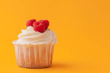 Sarı bir arka plan üzerinde krema ile lezzetli cupcakes