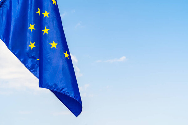 European Union flag against blue sky waving