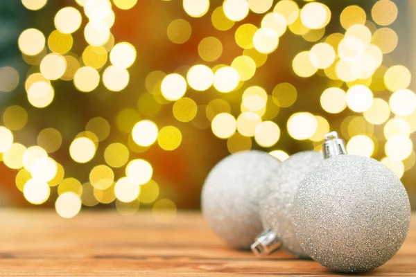 Kerstballen Een Houten Tafel Tegen Wazig Glimmende Bokeh Achtergrond — Stockfoto