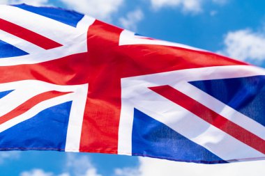 Mavi gökyüzünde rüzgarsal sallanan Birleşik Krallık Bayrağı