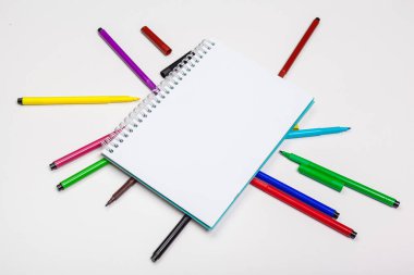 Farklı renklerde keçeli kalem seti ve metin için yeri olan boş bir çizim defteri