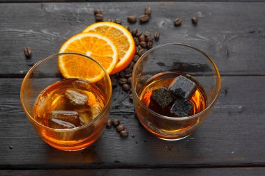 Viski ya da likör, kahve çekirdekleri ve ahşap arka planda portakal kesimi. Mevsimlik tatil kavramı.