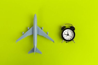 Seyahat konsepti. Çalar saati olan plastik uçak jeti yolcusu 