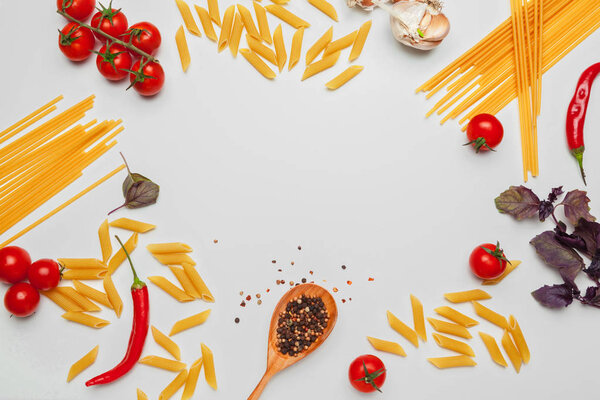 Pasta Spaghetti with ingredients for cooking pasta on a white background, top view.