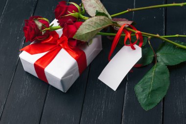 Sevgililer Günü. Kırmızı güller ve hediye kutusu ahşap masada