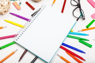 Farklı renklerde keçeli kalem seti ve metin için yeri olan boş bir çizim defteri
